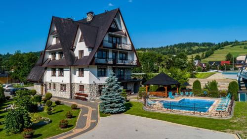 a large house with a swimming pool in front of it at DW Paweł in Zakopane