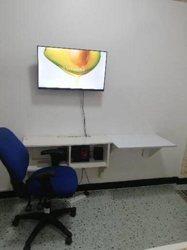 an office with a desk and two chairs and a screen at Neighbourly Nest in Mombasa
