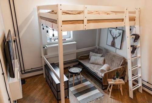 a room with two bunk beds and a couch at Little Universe in Liptovský Mikuláš