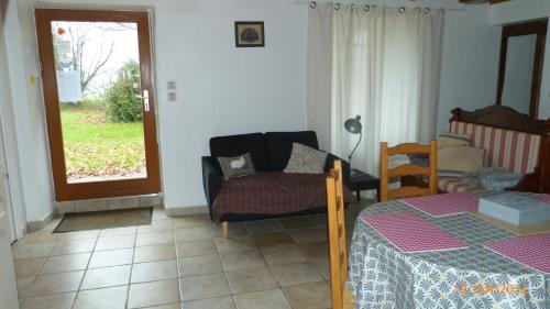 een woonkamer met een tafel, een stoel en een raam bij La ferme de la Cavalerie in Saint-Gonnery