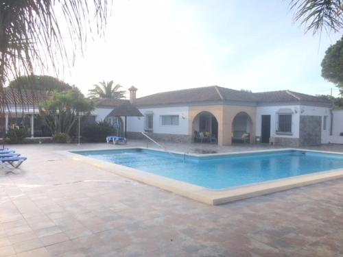 una gran piscina frente a una casa en Villa Torrealta, 4000 m2, estancia mínima en verano 7 días de sábado a sábado en Cádiz