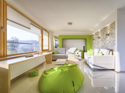 una sala de estar con una gran otomana verde en VisitZakopane - Aquapark Residence Lux Apartment, en Zakopane