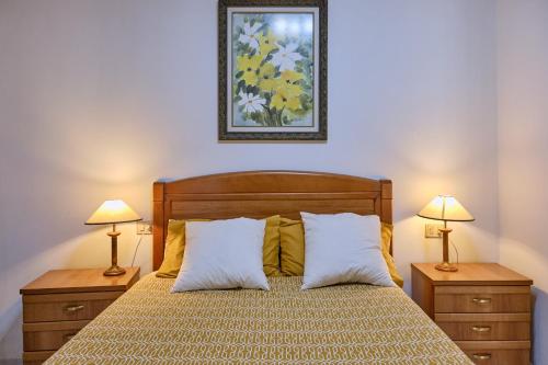 a bedroom with a bed with two night stands and two lamps at Apartamento en el centro de Portosin in Goyanes