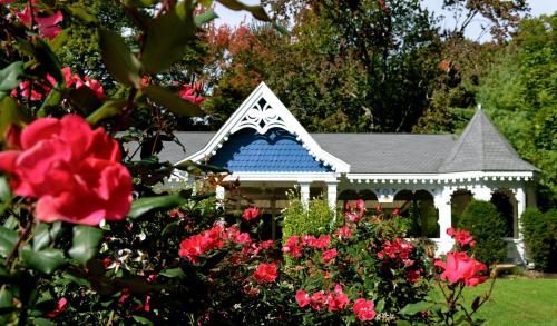 a gazebo in a garden with red flowers at Victoria Inn in Hampton