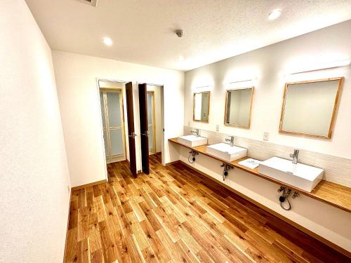 a bathroom with three sinks and two mirrors at Kagura Mitsumata Cottage in Yuzawa