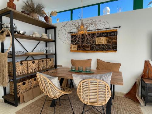 Casa MaRaHoBa - Relax at Pool and Beach في بلايا بلانكا: غرفة طعام مع طاولة وكراسي خشبية