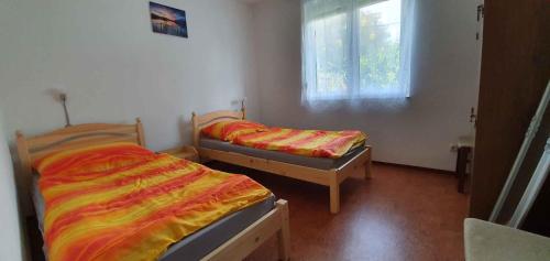 2 aparte bedden in een kamer met een raam bij Apartment Gyenesdias 3 in Gyenesdiás