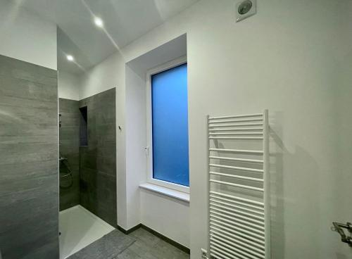 a bathroom with a window and a walk in shower at Appartement Moderne au Coeur du Luxembourg in Luxembourg