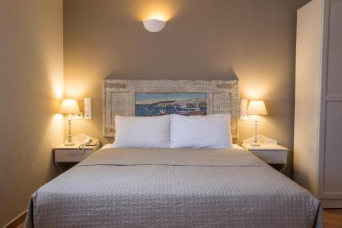 a bedroom with a large bed with two night stands at Aegean Village Beachfront Resort in Amoopi