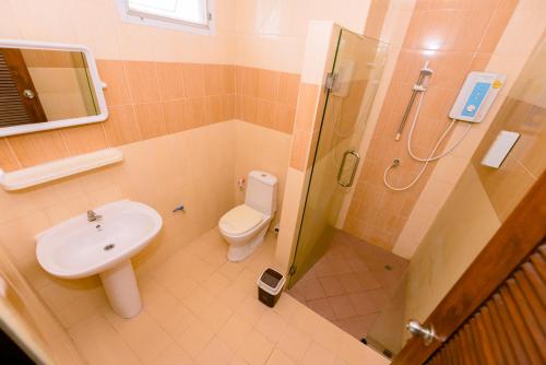 a bathroom with a shower and a toilet and a sink at BANDER HOTEL in Phu Khieo