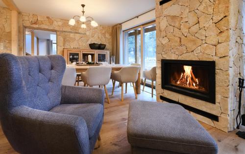 uma sala de estar com lareira e uma sala de jantar em TatraTravel VILA unlimited golf for 2 person incl em Tatranská Lomnica