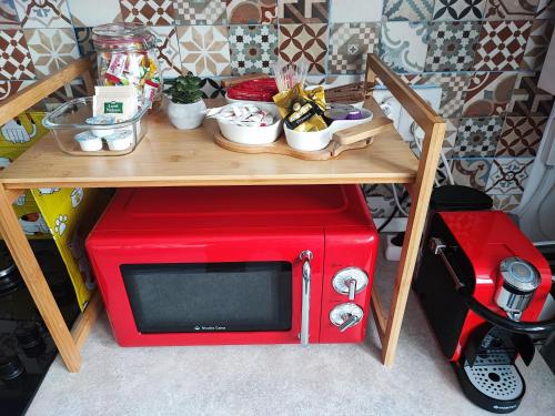 a red microwave sitting on top of a table at Quiet and Cozy 2 bedroom flat with free parking included in Floreşti