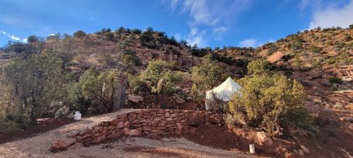 a mountain with a stone wall and a tent at Zion Glamping Adventures in Hildale