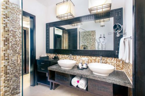 a bathroom with two sinks and a mirror at TUI BLUE Bahari Zanzibar in Pwani Mchangani