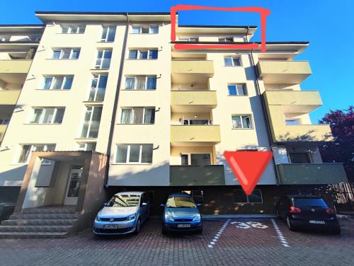 two cars parked in a parking lot in front of a building at Quiet and Cozy 2 bedroom flat with free parking included in Floreşti
