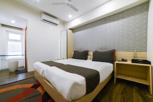 a bedroom with a large bed with a brick wall at RAAJ PEARL in Chennai