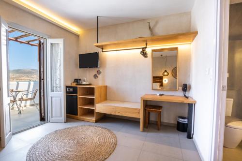 a room with a desk and a sink and a mirror at Aegean Village Beachfront Resort in Amoopi