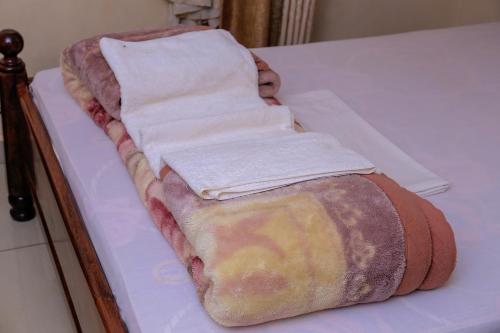 a bed with towels on top of a table at Precise Motel in Kampala