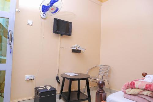 a room with a bed and a table and a tv at Precise Motel in Kampala