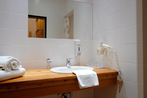 y baño con lavabo y espejo. en Alpenhotel Marcius, en Sonnenalpe Nassfeld