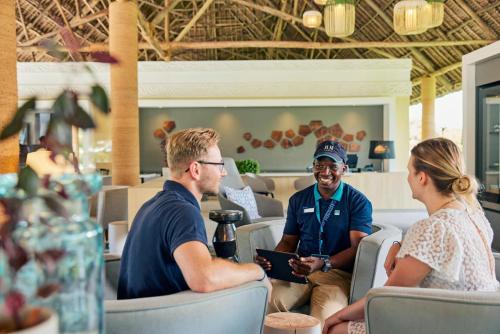 een groep mensen die in stoelen in een restaurant zitten bij TUI BLUE Bahari Zanzibar in Pwani Mchangani