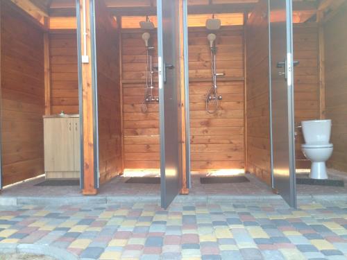 a bathroom with a toilet in a room with wooden walls at SZAŁASY drewniane nad rzeką BIEBRZA in Goniadz