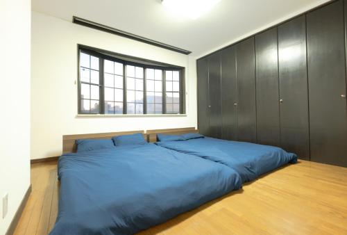 1 cama azul grande en un dormitorio con ventana en STAY IN ASAHIKAWA99 en Asahikawa