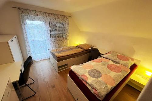 1 dormitorio con 2 camas, escritorio y ventana en Haus in Stadtnähe, gratis Parkplätze, en Wolfsberg