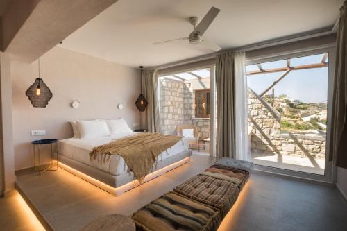 a bedroom with a bed and a large window at Aegean Village Beachfront Resort in Amoopi