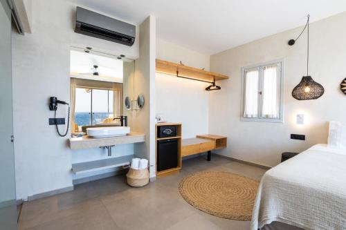a bathroom with a bed and a sink in a room at Aegean Village Beachfront Resort in Amoopi