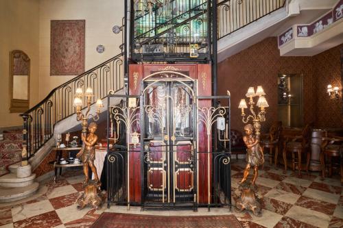 un vestíbulo con una escalera con una gran puerta de metal en Le Metropole Luxury Heritage Hotel Since 1902 by Paradise Inn Group, en Alejandría