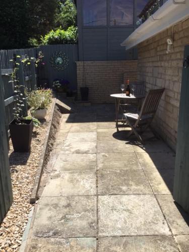 a patio with a chair and a table in a backyard at Bens Hollow with hot tub in Bredon