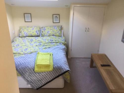 um quarto com uma cama com uma almofada amarela em Bens Hollow with hot tub em Bredon