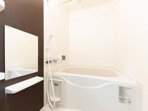 a white bathroom with a tub and a sink at Le Studio 五条高倉 in Kyoto