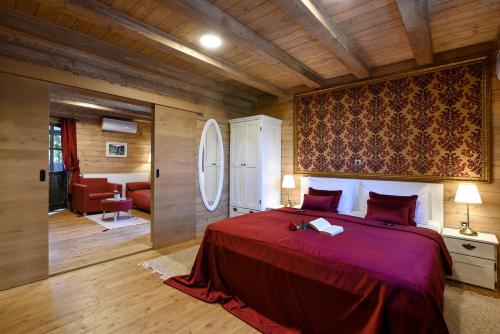 a bedroom with a large bed with a red blanket at Ethno Houses Plitvice Lakes Hotel in Plitvica selo