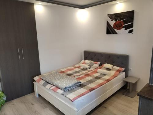 um quarto com uma cama com um cobertor xadrez em VIN Studio em Kruševac