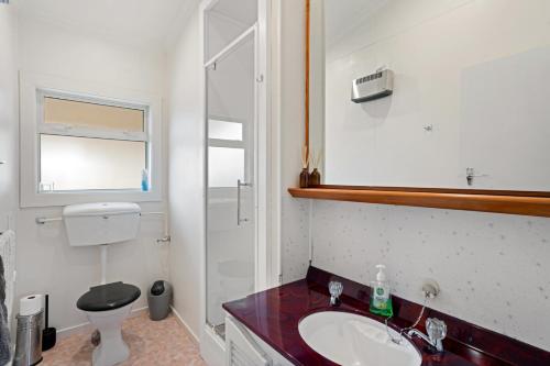 a white bathroom with a sink and a toilet at Thyme Away - Clyde Holiday Home in Clyde