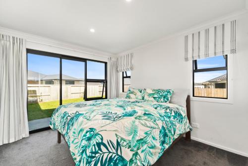 a bedroom with a bed and a large window at Puna Rise - Taupo Holiday Home in Taupo