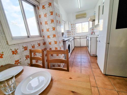 a kitchen with a wooden table and a white refrigerator at City View Rooms in Larnaka