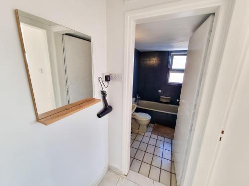 a bathroom with a tub and a toilet and a mirror at City View Rooms in Larnaka