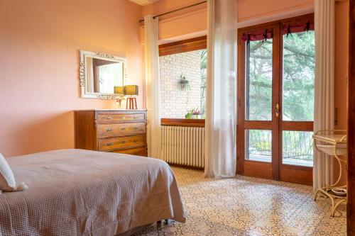 ein Schlafzimmer mit einem Bett, einer Kommode und einem Fenster in der Unterkunft Villa Poliziana San Benedetto in Montepulciano