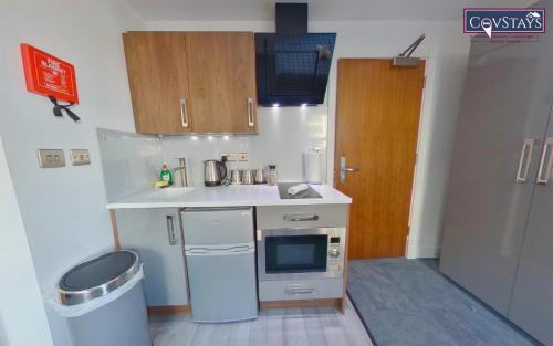 a small kitchen with a sink and a microwave at Victoria House - Deluxe Studios in Coventry City Centre, free parking, by COVSTAYS in Coventry