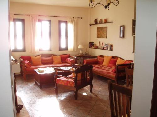 a living room with red and orange furniture and windows at Villa with breathtaking views and private beach in Agios Dimitrios