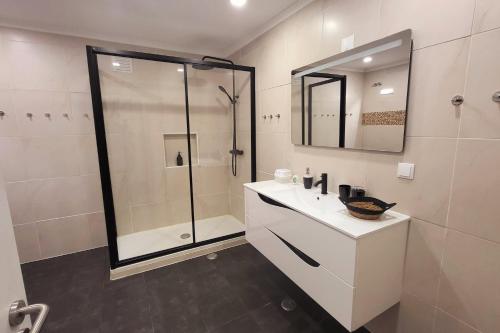 a bathroom with a shower and a sink and a mirror at Casa Borges in Charneca