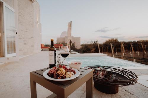 a table with a plate of food and a glass of wine at Chozos Resort in Agrelo