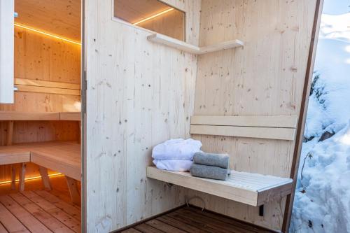 een sauna met handdoeken op een houten vloer bij Sirena Carezza Apartment Masarè in Carezza al Lago