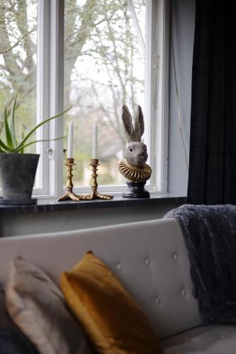 a bunny sitting on a window sill with two candles at Lomma Station Inn in Lomma