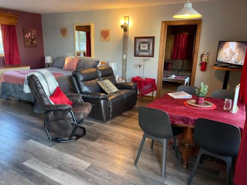 a bedroom with a bed and a couch and a table at Auberge et Chalets sur le Lac in Lac-Mégantic