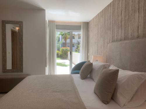 1 dormitorio con 1 cama grande con almohadas blancas en Royal Banus, en Marbella