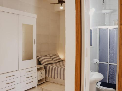 a small bedroom with a bed and a sink at Flats Beija-Flor in Itacaré